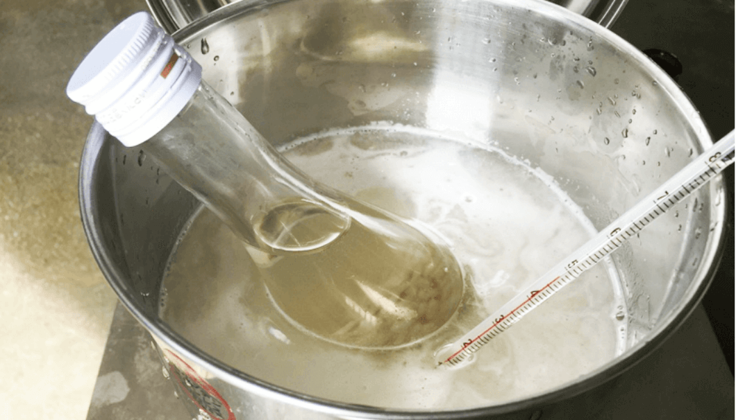 甘酒を造っている最中に、お湯で瓶に入れた麹を温めている写真