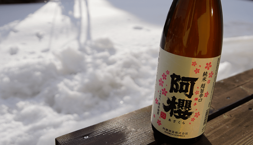 雪をバックにした阿櫻 純米 超旨辛口(阿櫻酒造株式会社／秋田県横手市)のボトル