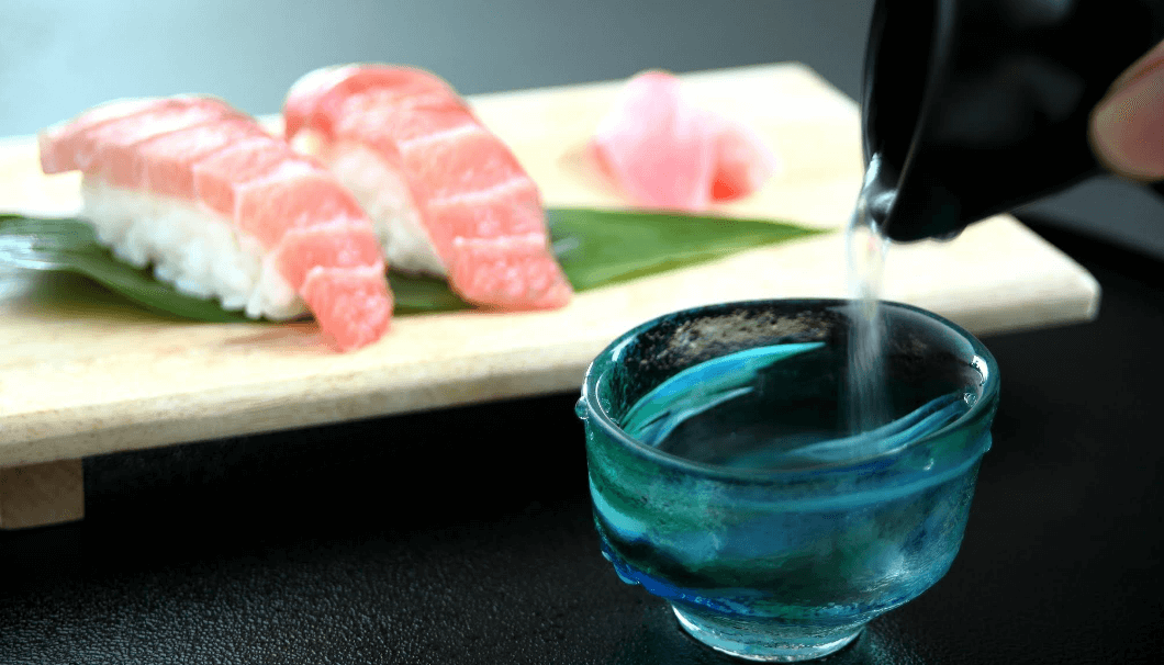 お寿司の前で日本酒が注がれている写真