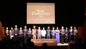 「SAKE COMPETITION 2018」の会場、ステージに上位入賞酒の蔵元が並ぶ様子