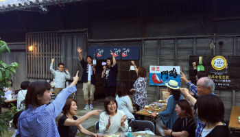 徳島県鳴門市の株式会社本家松浦酒造場で開催される日本酒イベント「ナルトタイ蔵蔵たちきゅう」の様子。蔵の前でお酒を飲んで楽しんでいる写真