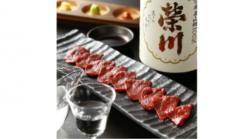 榮川酒造株式会社(福島県耶麻郡)のお酒「榮川」のボトルと、お酒の入ったグラス、馬刺しの写真