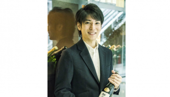 最年少で「SSI地酒検証研究会」に所属・活動している並里直哉氏がボトルを持って立っている写真