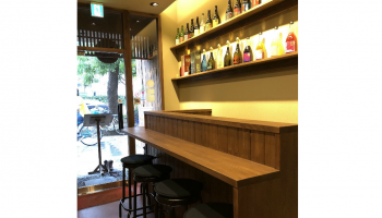 リニューアルされた「NIPPONno SAKE小鼓御里」の店内写真(日本酒柄が並んだ棚と、カウンター)