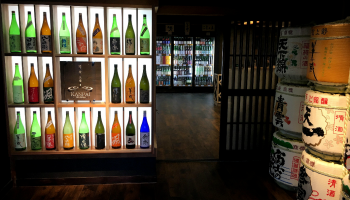 三重県の酒と食の専門店「KANPAI ISESHIMA 」の内観写真。冷蔵庫と酒樽が並ぶ店内
