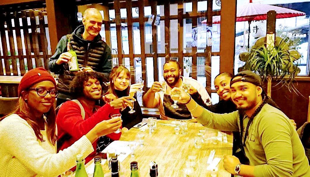 松井酒造で日本酒を楽しむ外国人旅行者のグループ